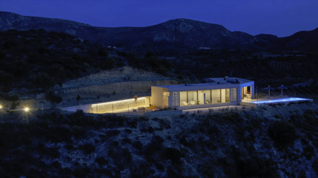 Über die moderne Architektur im Olivenhain schreibt "Urlaubsarchitektur": "The Boomerang House ist ein B&B mit nur zwei Gästezimmern, das abgeschieden in einem Olivenhain nahe dem Dorf Sivas im Süden von Kreta liegt. Das Haus wurde so gebaut, dass es sich bestmöglich in die Umgebung einfügt. Die an einen Bumerang erinnernde Form und die Materialien Beton, Glas und Holz prägen das Gebäude, das optisch fast im Hang verschwindet. Das knallrote Geländer des Poolbereichs setzt ein farbliches Ausrufezeichen. Das Haus besteht aus zwei Teilen: in einem Flügel befinden sich die Gästezimmer, in dem anderen die Küche sowie die Wohnung der Betreiber. Zwischen den durch ein Betondach verbundenen Baukörpern liegt die Pergola, unter der morgens das Frühstück serviert wird."